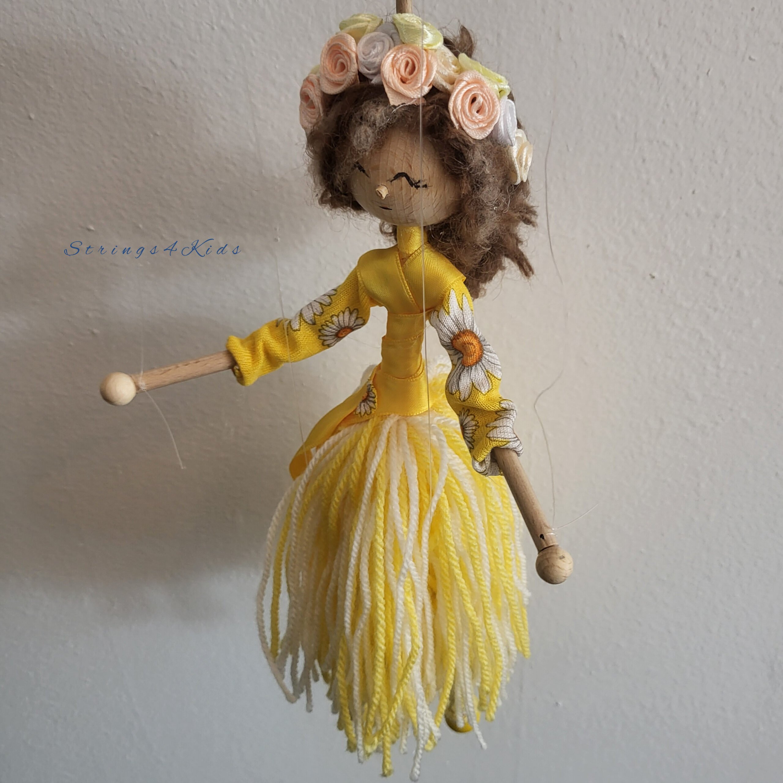 Bloemenmeisje marionet met gele kleren en bloemen in haar haar.