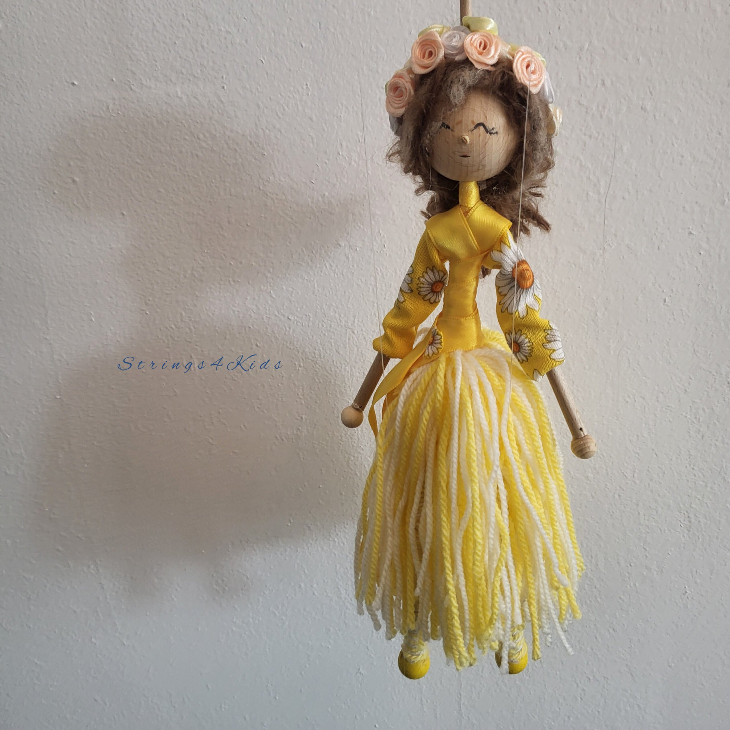 Bloemenmeisje marionet met gele kleren en bloemen in haar haar.