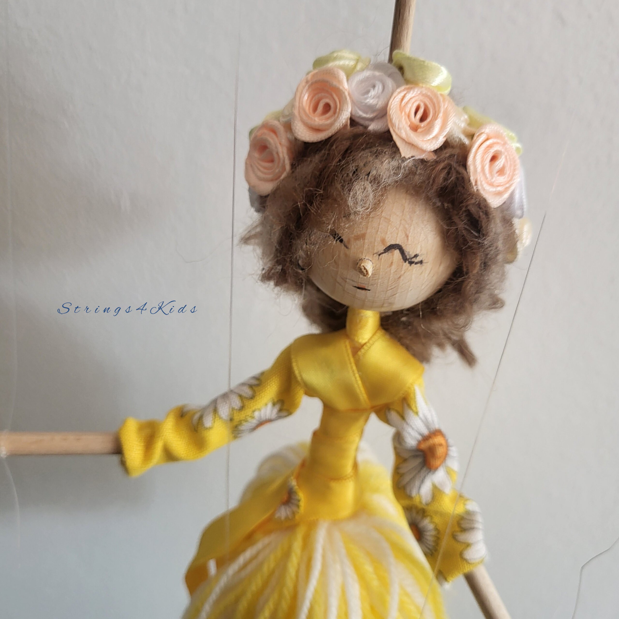 Bloemenmeisje marionet met gele kleren en bloemen in haar haar.